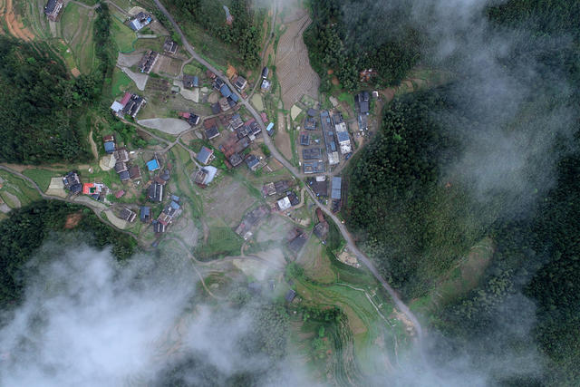 2024年4月18日，雨后的全国文明村湖南省桂东县大塘镇春风村，流云在村上方飘来飘去，森林、民房、交通、产业等忽隐忽现，一幅美丽的文明、生态、梦幻画卷。