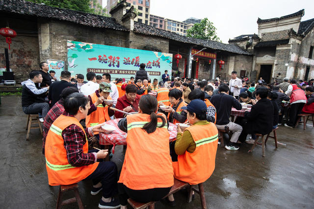 “一碗粥，温䁔一座城”
2024年5月5日，是24节气中的立夏，这天一大早，耒阳市蔡子池街道金南社区昆壁湾的妇女同胞们就忙了起来。
在耒阳，过立夏节有个俵（biao)立夏粥的习俗。立夏这天家家户户都要煮立夏粥，里面放有猪肉、猪肝、粉丝、干笋、腊肉、雪豆、米粉团、鸡蛋、豆芽菜等等上十种肉、菜。每家都要煮上一大锅，煮熟以后，全村家家户户都要去送上一碗。以示邻里和气，相亲相爱。
今天在昆壁湾又要煮立夏粥了。这是继2021年开始由耒阳市委宣传部、耒阳市文旅广体局主办，耒阳市非遗保护中心、蔡子池街道金南社区、湖南知韵餐饮文化有限公司（粥面之韵）承办的第四届“一碗粥  温暖一座城”的俵立夏粥活动。主要是请环卫工人一起品尝立夏粥。
天还未亮，昆壁湾的大妈们就早早的忙碌了起来，生火的生火，洗菜的洗菜，切菜的切菜，她们要赶在早上8点之前把粥煮出来。
8点未到，环卫工人们陆陆续续来到了现场，耒阳市政协副主席、市文旅广体局局长陆小勇和宣传部的肖副部长也到了现场。随着一声令下，志愿者们将煮好的立夏粥抬到了广场，六十多位环卫工人和部分在耒阳旅游的游客一起品尝了这道热气腾腾的、独特的耒阳美食。
                       （图、文供稿：耒阳曾启武）