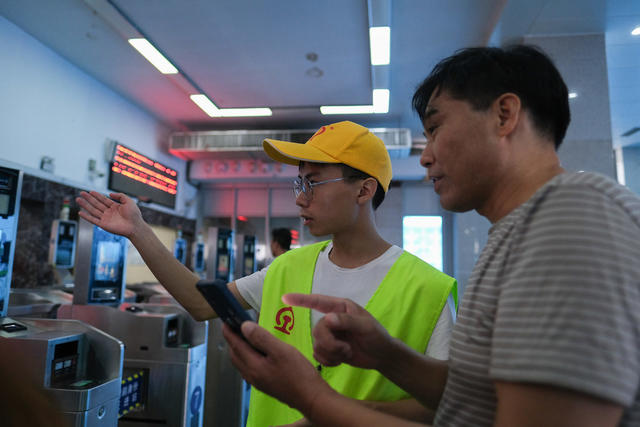 2024年8月29日，湖南省长沙火车站，大学生铁路志愿者为旅客指路。随着暑假接近尾声，学生客流、探亲客流、旅游客流叠加，铁路志愿者弘扬志愿精神，服务旅客踏上返程高峰。林道辉 摄