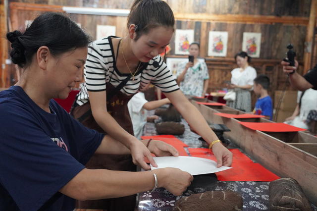 9月7日，湖南省隆回县滩头木版年画技艺传习馆，非遗传承人在向游客展示年画，并教游客印制年画。近年来，该县在非遗基地、景区、学校等地广设传习馆，弘扬非遗文化。
（ 罗理力 伍冬云 摄影报道）