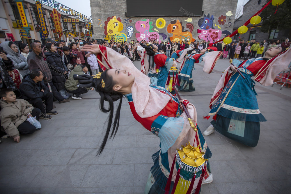 2026年2月22日，河南安阳，游客在殷墟考古小镇观看非遗灯艺表演。
位于殷墟片区的纱厂（原豫北棉纺织厂）考古小镇，以“非遗+潮玩”为核心理念，融合传统灯艺与现代夜游体验，打造沉浸式文化年节场景。
小镇集结了走马灯、滚灯、鱼灯、转花灯四大传统灯艺，通过动态表演和大巡游形式呈现。夜幕降临时，璀璨花灯轮番登场，光影流转间展现非遗技艺的灵动之美。
