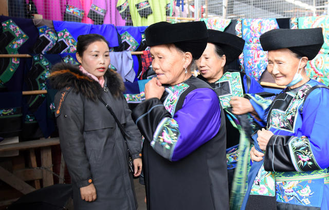 集市   苗家 妇女 挑选 苗服 鞋帽 银饰 民族 传统 迎 新春 