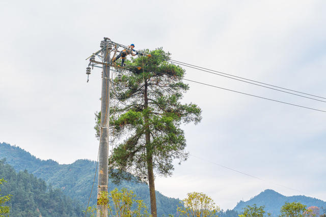 电力工人在高空架线  以确保乡村寒冬供电