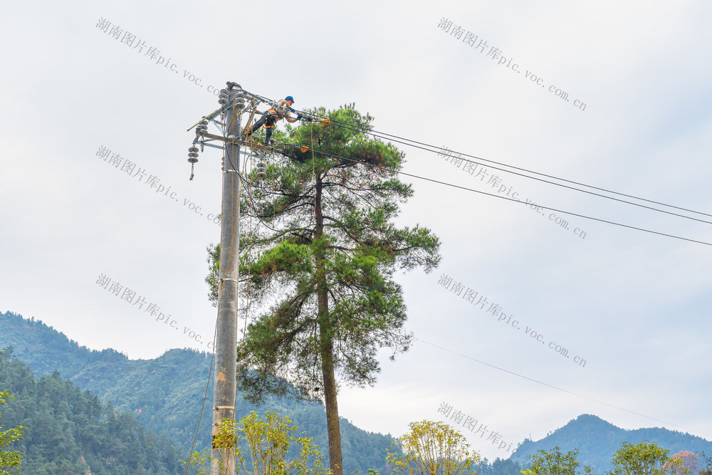 电力工人在高空架线  以确保乡村寒冬供电