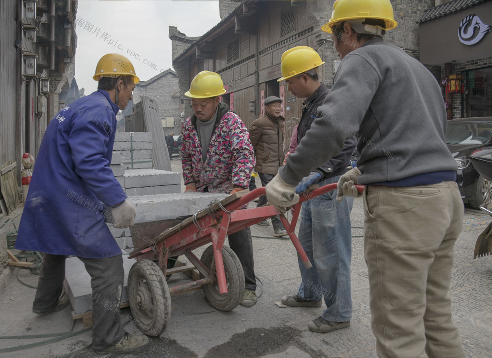 2025年元旦一群一线建筑工人在武冈市西直街庆丰老巷施工青石板和卵石路。