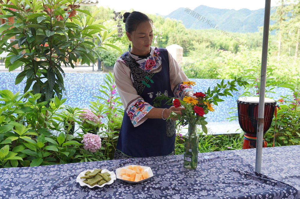 6月17日，绥宁县关峡苗族乡花园阁村苗家阿妹黄湘萍在喂鸭、插花、打理民宿。近年来，在文旅部门的指导下，她新建民宿、农家乐餐厅，栽种蔬果花草，喂养家禽，探究乡村旅游业，成为当地乡村旅游致富带头人。
