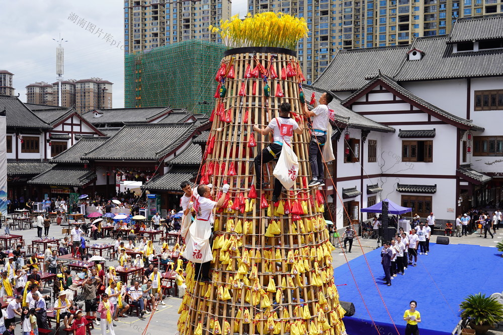 6月30日，湖南省武冈市在同富楼举行“六月六尝新节”庆祝活动，大家免费品尝当地特色美食，欣赏男子们登高“抢富袋”，现场气氛祥和而热闹。