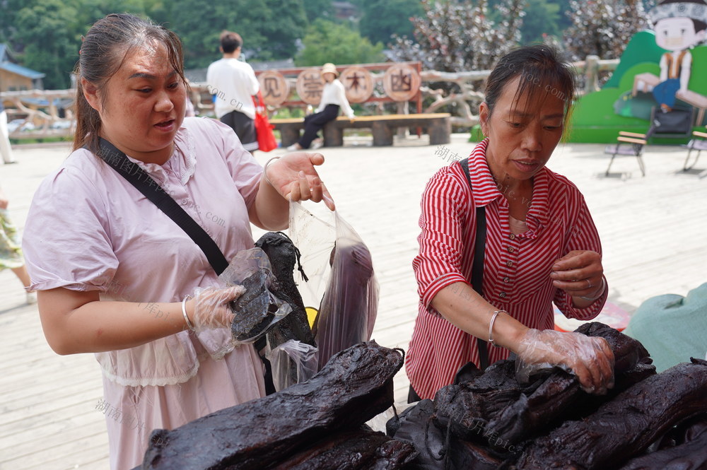 乡村旅游助销土特产（图）

7月27日，湖南省隆回县虎形山瑶族乡崇木凼村，游客在选购腊肉、猪血丸子。随着乡村旅游的盛行，该村土特产畅销。