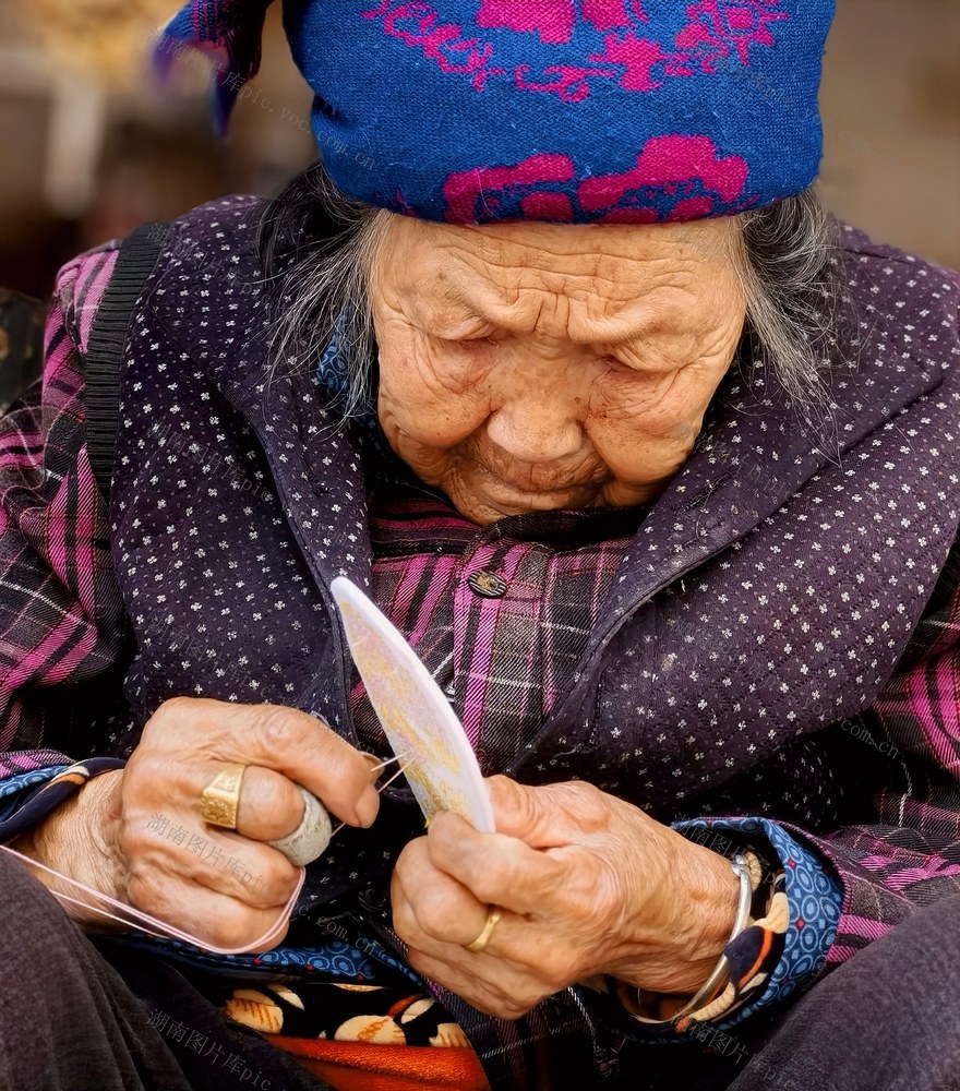 她有一双好眼睛，九十高龄，不用戴眼镜，每天坐在自家门前绣鞋垫。