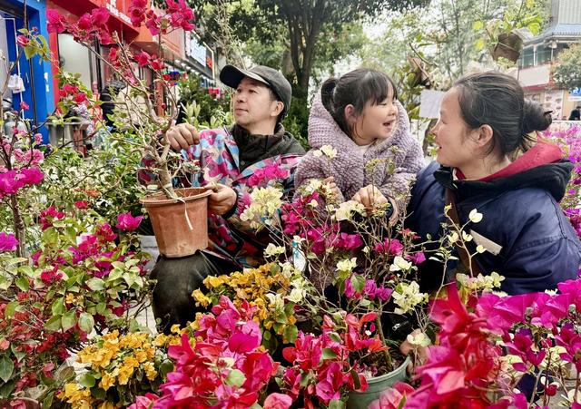 3月7日，通道侗族自治县城东大巿场，一位孩子陪伴父母在选购鲜花。三八国际妇女节来临之际，该县鲜花巿场迎来热销，让这个节日充满了温馨与浪漫。
的陪伴
