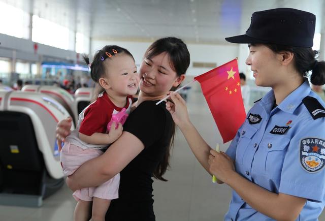 怀铁民警给候车小朋友送红旗共庆六一
