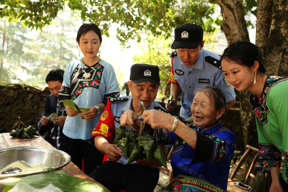 怀化铁警帮助苗乡留守老人包粽子